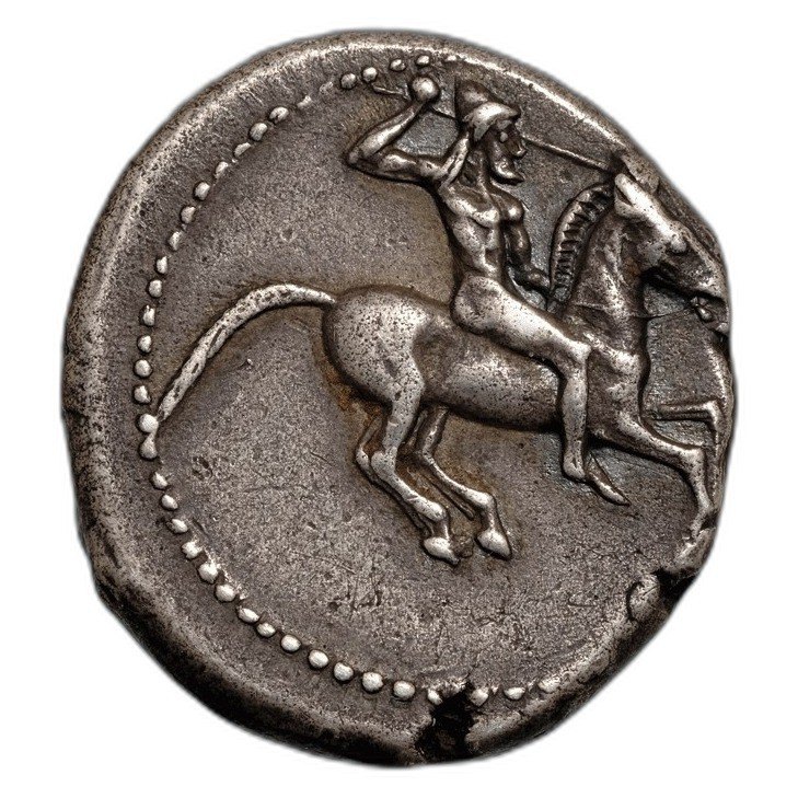 The coin photographed in hand, obverse