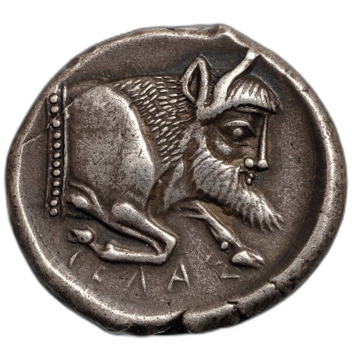The coin photographed in hand, reverse